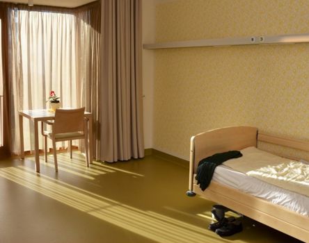 Una camera con un letto singolo e un tavolino vicino alla finestra